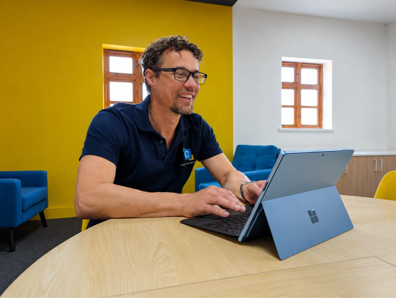 A Confidence IT team member working on a Surface device in the office