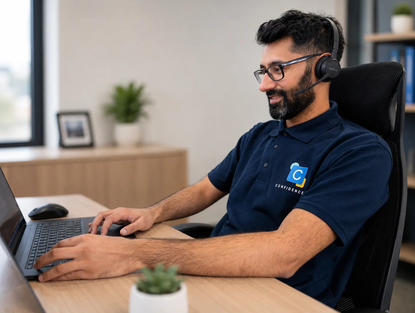 A Confidence IT team member on a headset taking a call at their desk